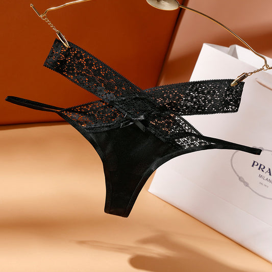 Black lace lingerie on a hanger with a Prada bag in the background
