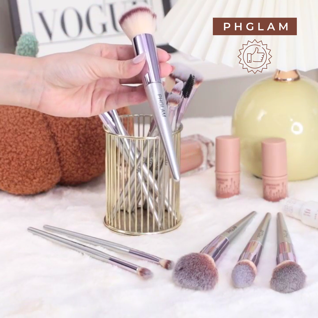 Makeup brushes in a holder with PHGLAM branding on a white surface.