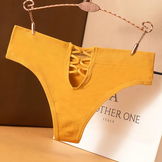 Yellow lace-trimmed underwear on a hanger with a brand name visible in the background.