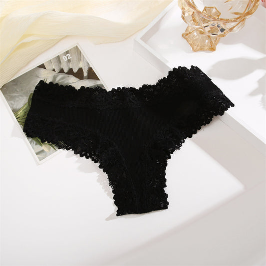 Black lace lingerie set on a white surface with a decorative background