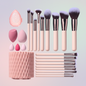 Makeup brush set with pink holder and various brushes on a light blue background
