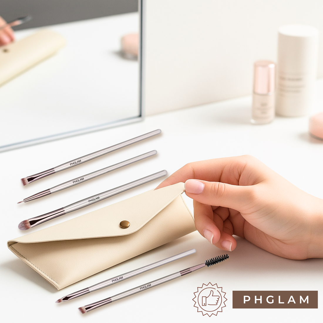 Set of makeup brushes with a beige pouch on a light surface, featuring the PHGLAM brand.