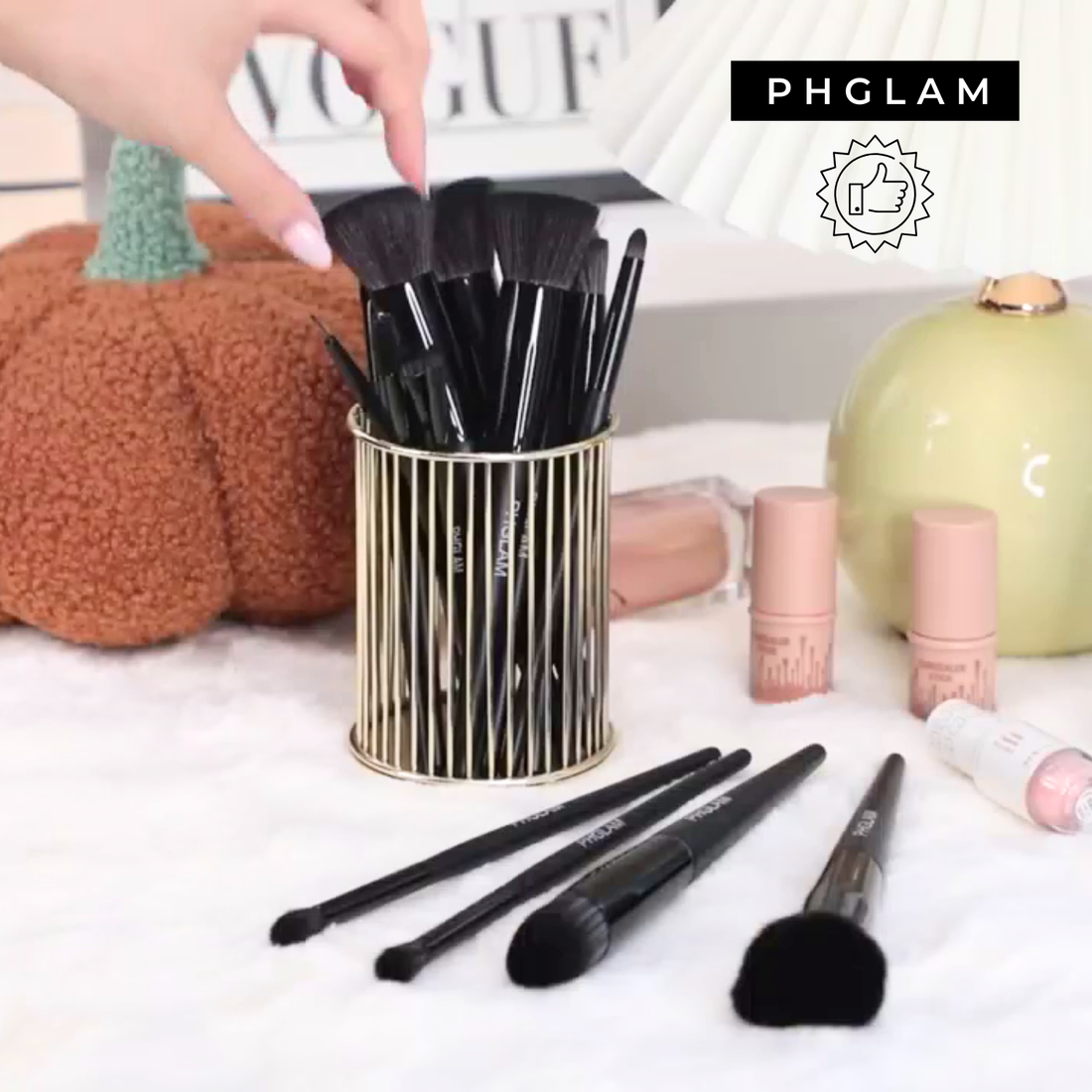 Makeup brushes in a holder with 'PHGLAM' branding on a decorative background