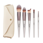 Set of makeup brushes with a beige case on a white background
