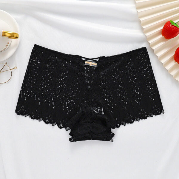 Black lace underwear on a white fabric background with decorative elements.