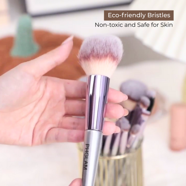 Makeup brush with eco-friendly bristles held by a hand, with text indicating safety and toxicity.
